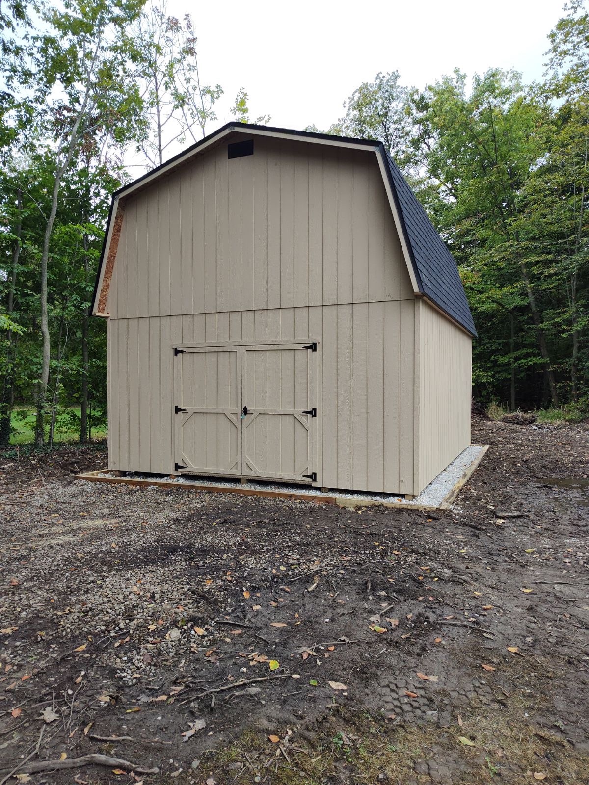 New barn-style shed sitting on a finished gravel pad in Aurora, Ohio