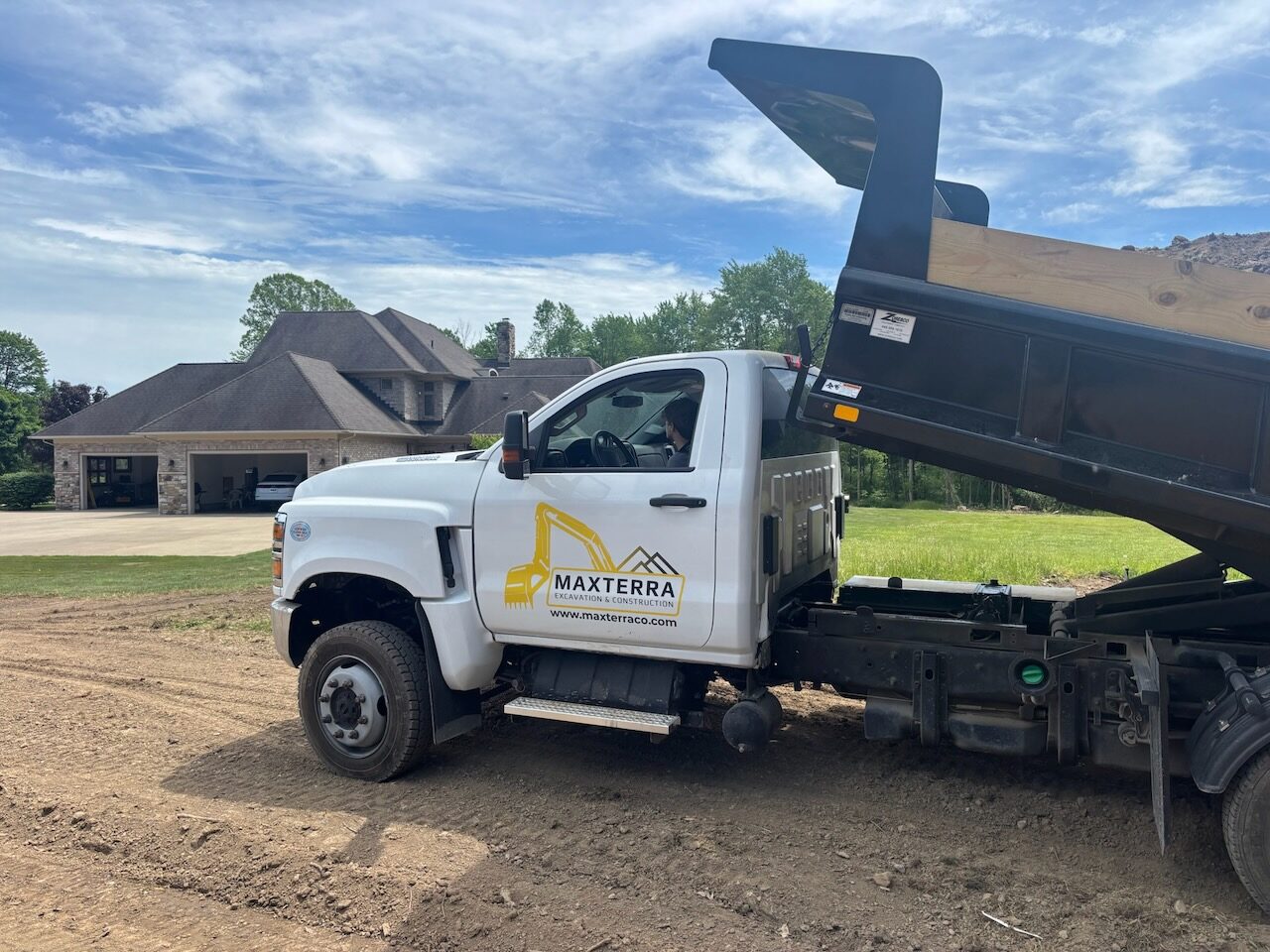 Maxterra dump truck delivering gravel at a residential grading site in Northeast Ohio
